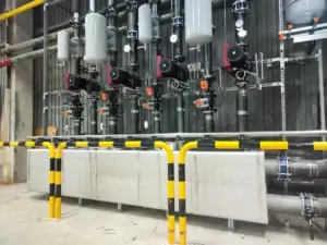 Sústava priemyselných čerpadiel s elektronickým riadením a ochranou, súčasť veľkej technologickej linky s kovovým rozvodom.