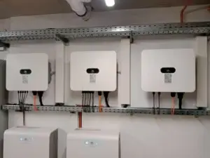 Tri napojené striedače Huawei ako súčasť fotovoltického systému na stene technickej miestnosti.