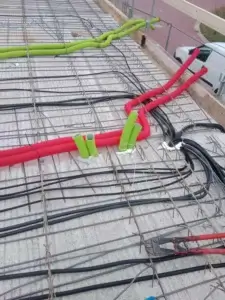 Electrical installation in reinforced concrete ceiling slab with protective conduit for future cabling.