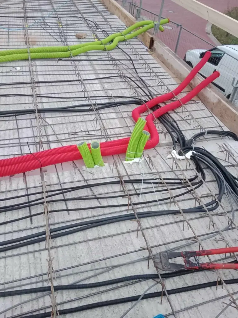 Electrical installation in reinforced concrete ceiling slab with protective conduit for future cabling.
